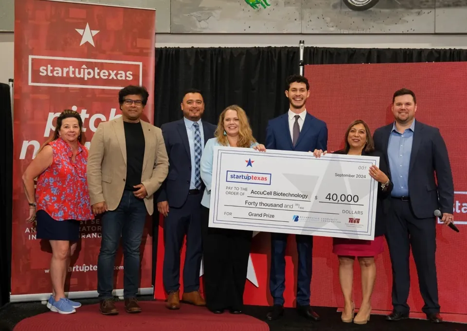 Ethan Atlan holding AccuCell's Startup Texas grand prize check on stage